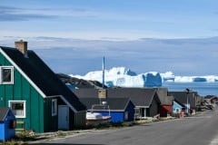 2021-08-05-13.58.19 De farvede huse i Ilulissat med isbjerge og Diskobugen i baggrunden